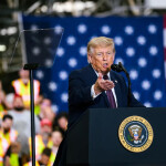 U.S. President Donald Trump giving a speech in front of a flag