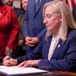 Virginia Governor Abigail Spanberger signing a document