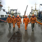 Five fishermen walking at a fishing wharf