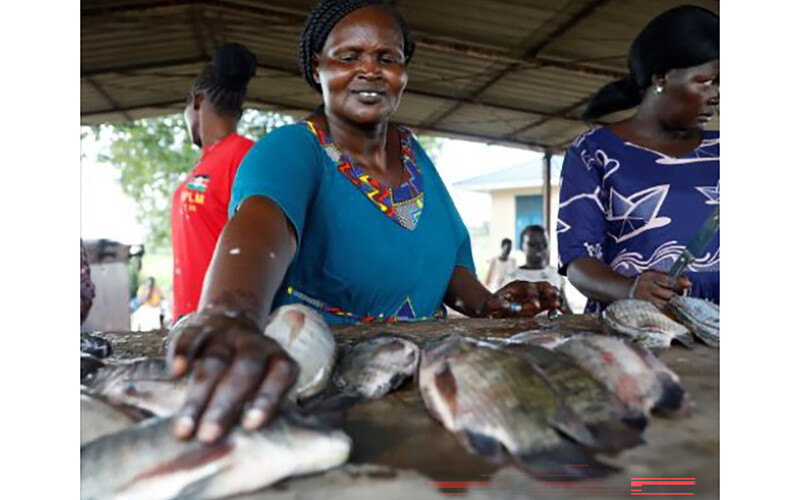 A South Sudanese woman handling fish