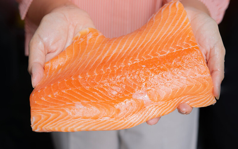 A person holding an Atlantic salmon fillet
