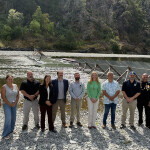 Tribal and government officials standing on a river bank