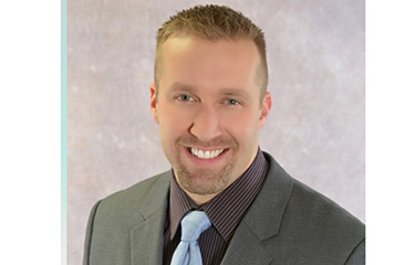 A headshot of Travis Riepenhoff