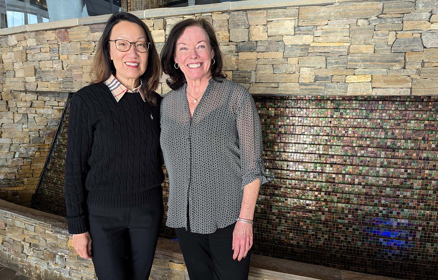 SNP Founder and President Linda Cornish and Vice President of Marketing and Communications Sarah Crowley standing in front of a fountain