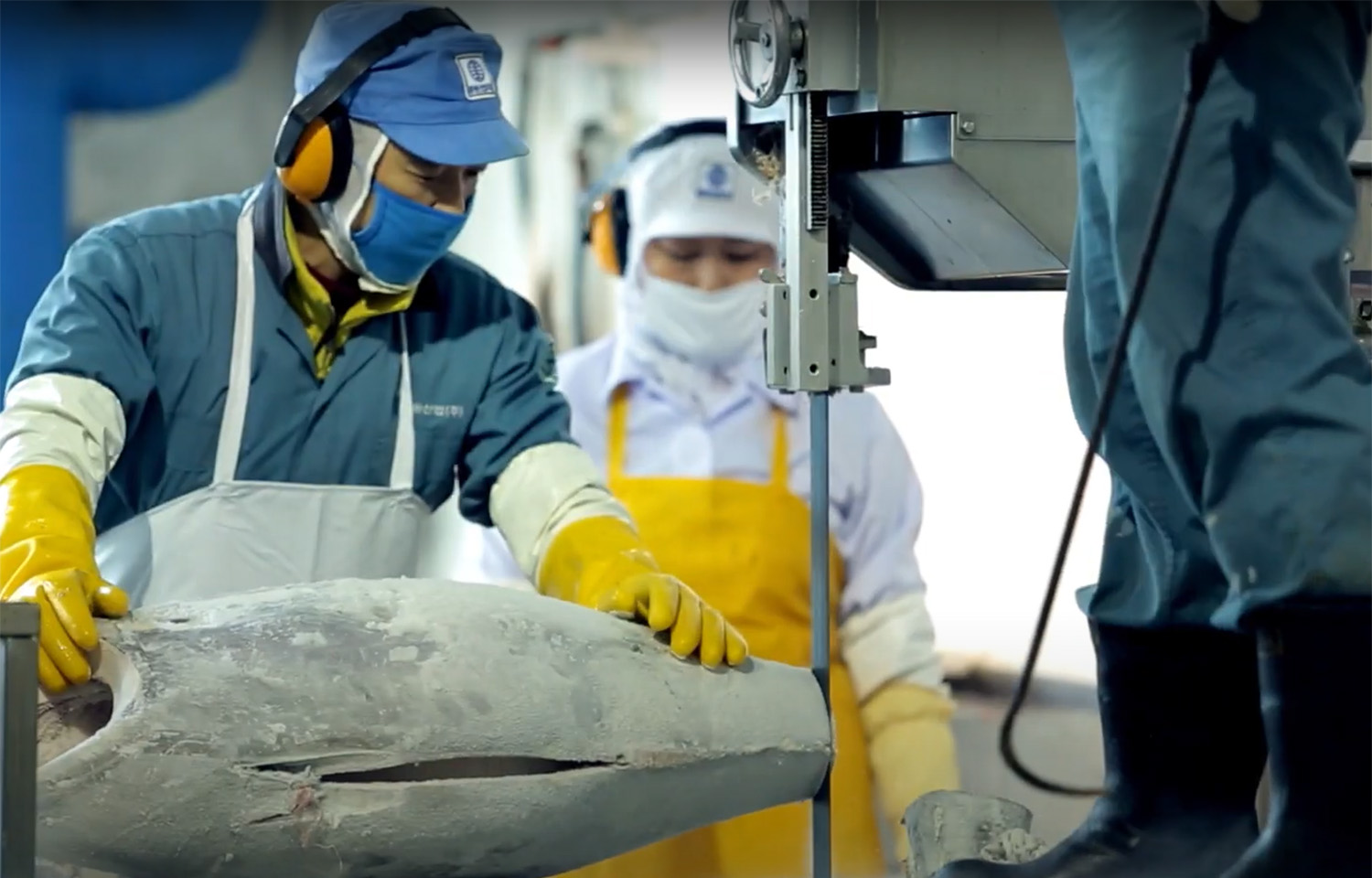A Dongwon Industries employee cutting a tuna