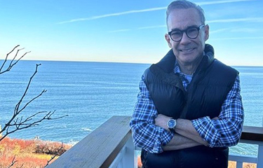 Roger Berkowitz standing on a deck that overlooks the ocean.