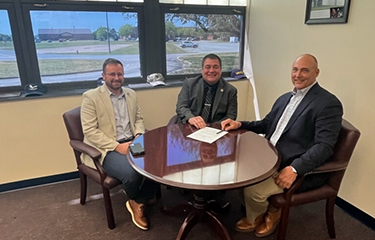 Virginia Secretary of Natural Resources Travis Voyles, Virginia Marine Resources Commission (VMRC) Commissioner Jamie Green, and Ocean Harvesters CEO Monty Deihl sign a MoU.