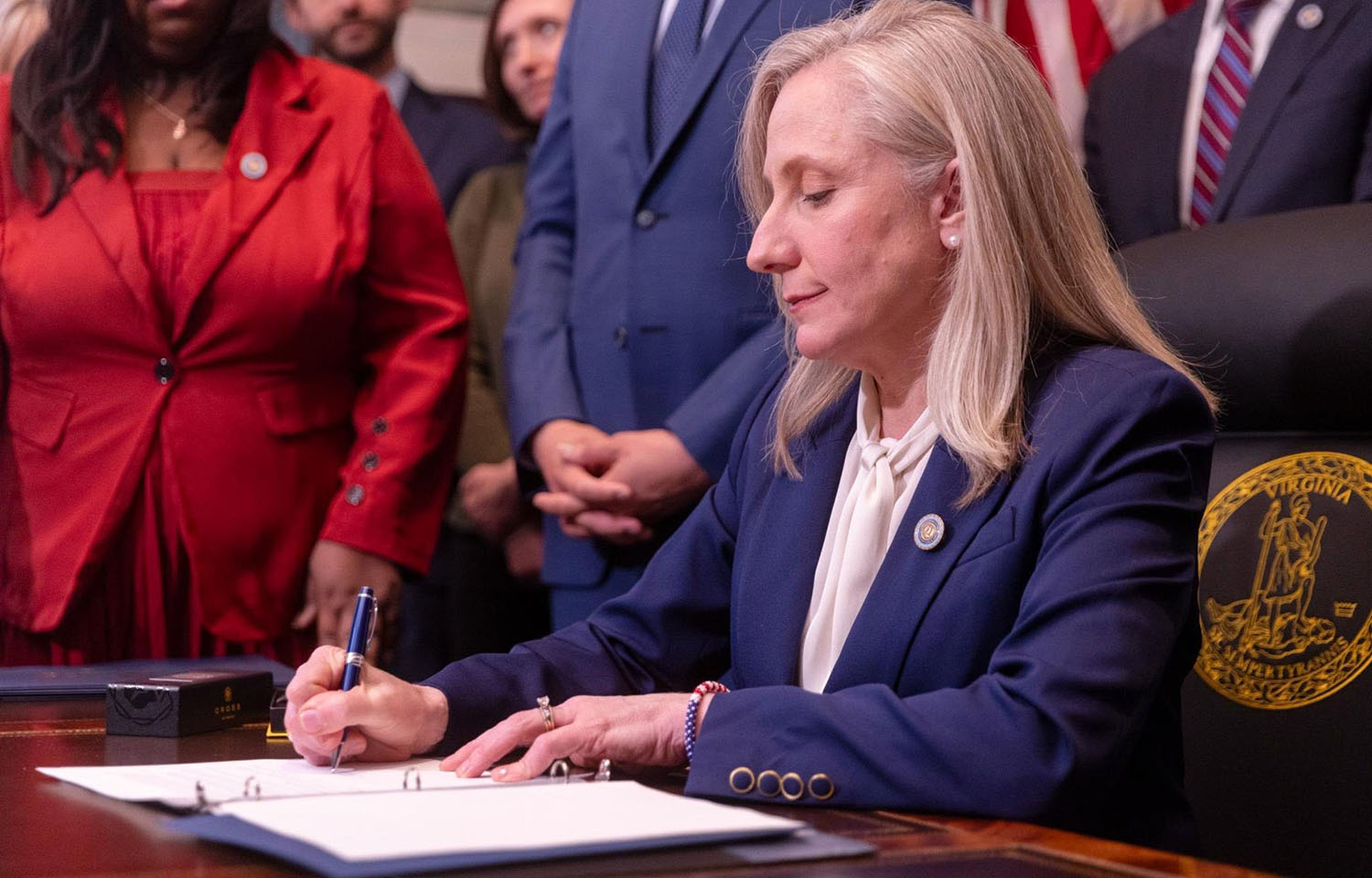 Virginia Governor Abigail Spanberger signing a document