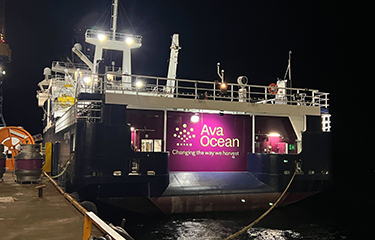 A banner promoting Ava Ocean on the back of a Norwegian fishing vessel.