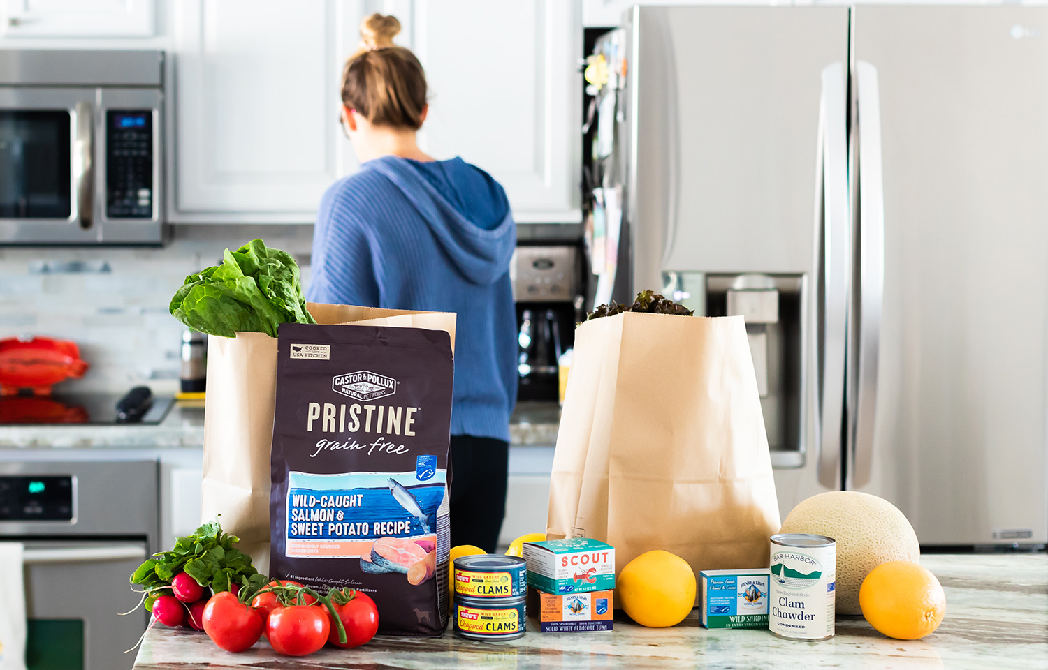 A woman in a kitchen with bags of MSC-certified seafood products
