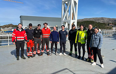 Staff members of Frøy standing near the oceanside.