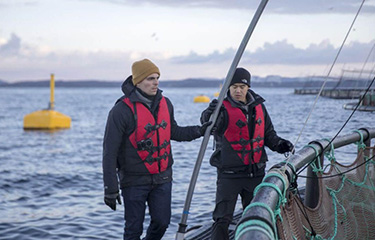John Costantino and Tony Chen from Manolin at an aquaculture net pen.