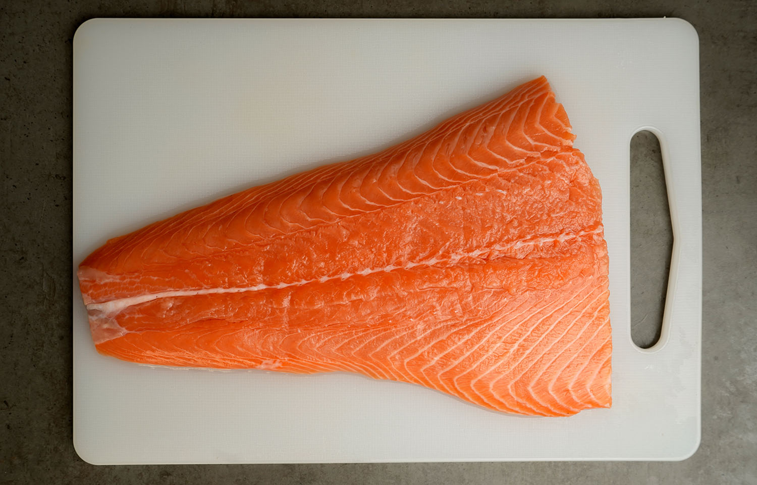 A fillet of salmon on a cutting board