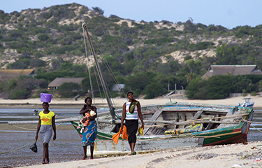 Small fishers walk along the beach in Mozambique.