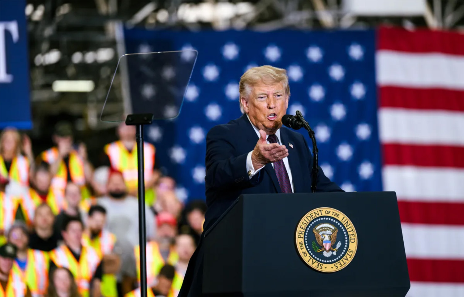 U.S. President Donald Trump giving a speech in front of a flag