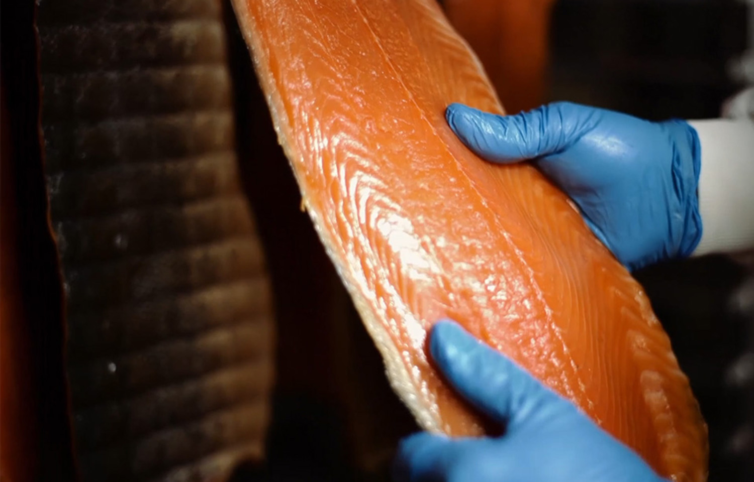 A worker handling some of Associated Seafoods' smoked salmon
