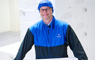 Salmon Evolution employee holding a box of salmon.